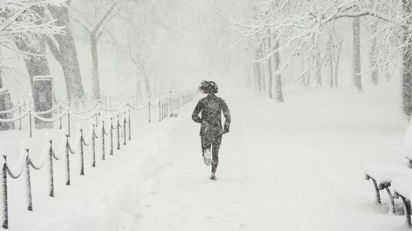Человек занимается бегом во время снегопада в США