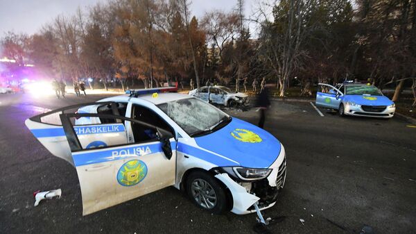 Поврежденные полицейские машины на улице Алма-Аты, Казахстан