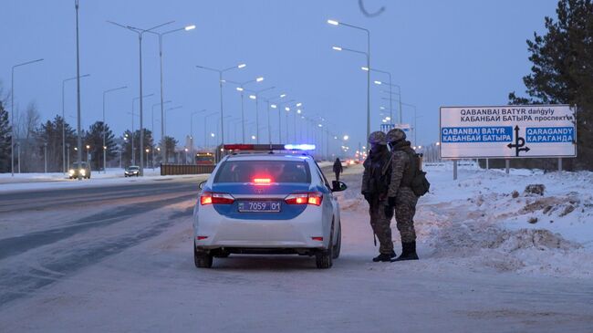 Сотрудники полиции и военнослужащие дежурят на одной из улиц в Нур-Султане