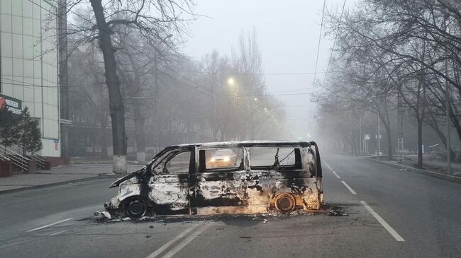 Автомобиль, сожженный во время протестов, вызванных повышением цен на топливо, на дороге в Алма-Ате, Казахстан