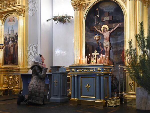 Верующая перед началом Рождественского богослужения в соборе Казанской иконы Божией Матери в Казани