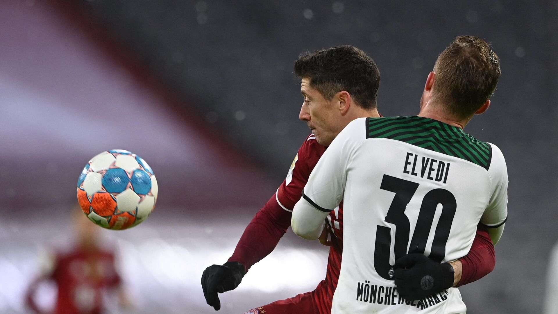 Bayern Munich's Polish forward Robert Lewandowski (Back) and Moenchengladbach's Swiss defender Nico Elvedi vie for the ball during the German first division Bundesliga football match FC Bayern Munich v Borussia Moenchengladbach in Munich, southern Germany on January 7, 2022. (Photo by CHRISTOF STACHE / AFP) / DFL REGULATIONS PROHIBIT ANY USE OF PHOTOGRAPHS AS IMAGE SEQUENCES AND/OR QUASI-VIDEO - РИА Новости, 1920, 08.01.2022