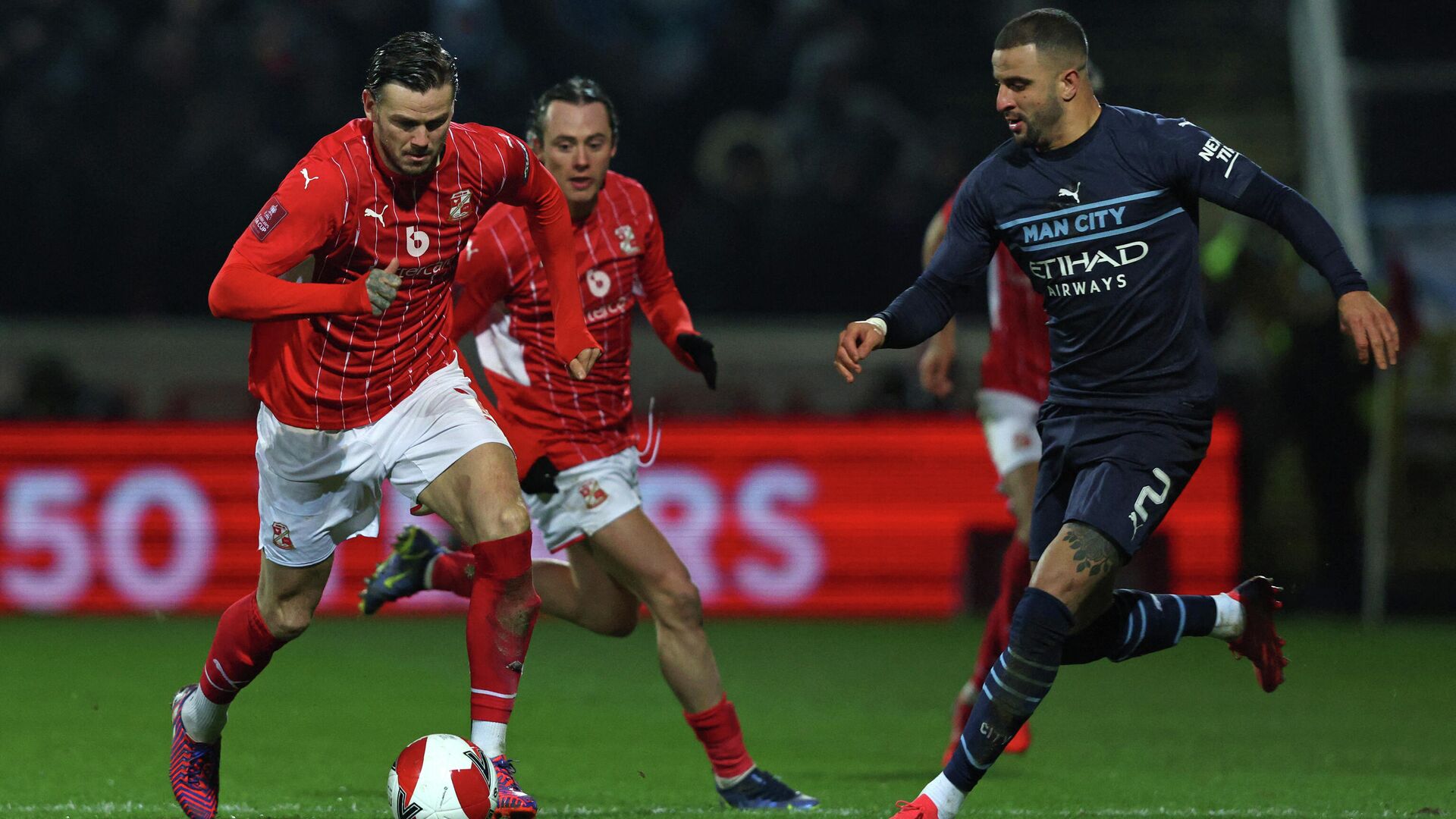 Manchester City's English defender Kyle Walker (R) vies with Swindon Town's English midfielder Ben Gladwin  (L) during the English FA Cup third round football match between Swindon Town and Manchester City at County Ground, Swindon in western England on January 7, 2022. (Photo by Adrian DENNIS / AFP) / RESTRICTED TO EDITORIAL USE. No use with unauthorized audio, video, data, fixture lists, club/league logos or 'live' services. Online in-match use limited to 120 images. An additional 40 images may be used in extra time. No video emulation. Social media in-match use limited to 120 images. An additional 40 images may be used in extra time. No use in betting publications, games or single club/league/player publications. /  - РИА Новости, 1920, 08.01.2022