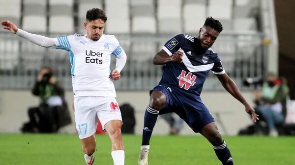 Marseille's Turkish forward Cengiz Under (L) fights for the ball with Bordeaux' French defender Enock Kwateng during the French L1 football match between Girondins de Bordeaux and Olympique de Marseille (OM) at the Matmut stadium in Bordeaux, southwestern France, on January 7, 2022. (Photo by ROMAIN PERROCHEAU / AFP)