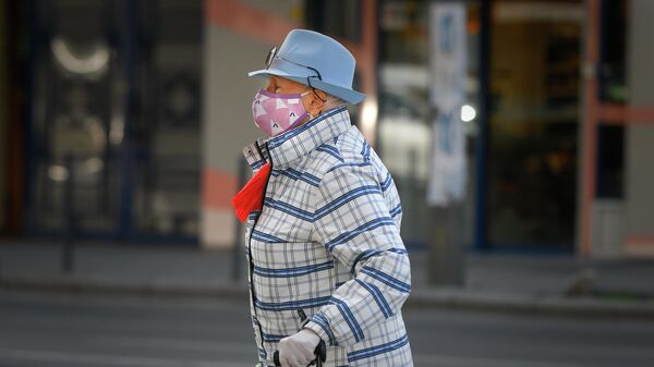 Женщина в защитной маске на улице в Бухаресте, Румыния
