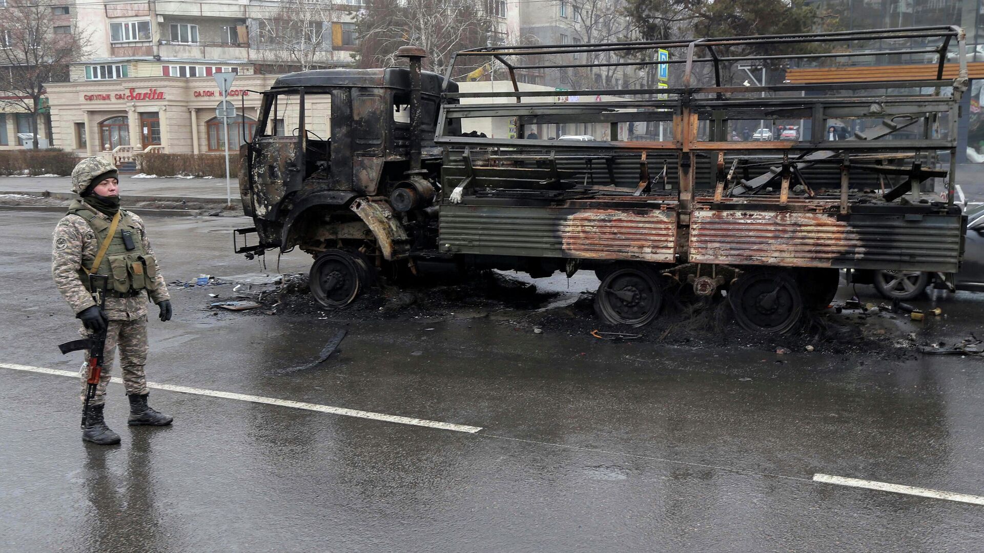 Военный возле сгоревшего грузовика на одной из улиц в Алма-Ате - РИА Новости, 1920, 08.01.2022