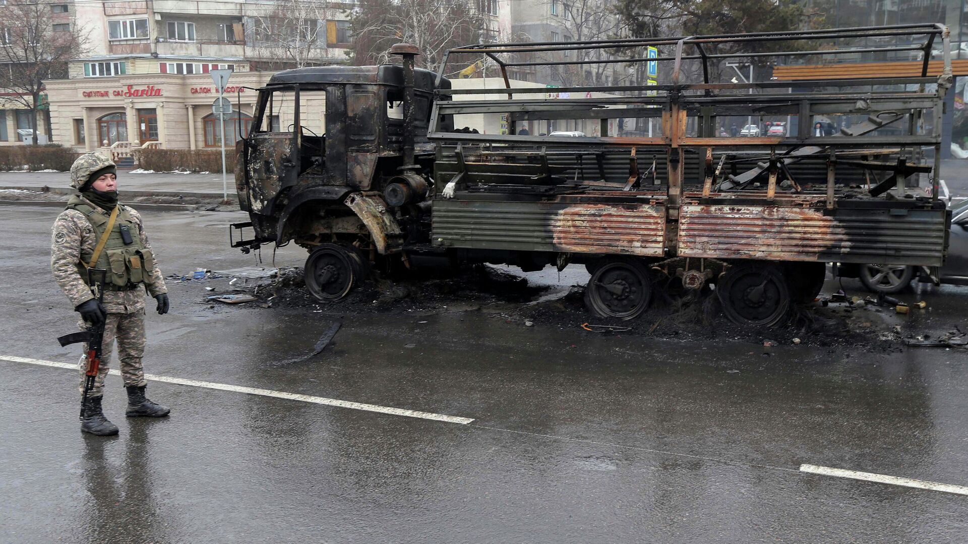 Военный возле сгоревшего грузовика на одной из улиц в Алма-Ате - РИА Новости, 1920, 08.01.2022