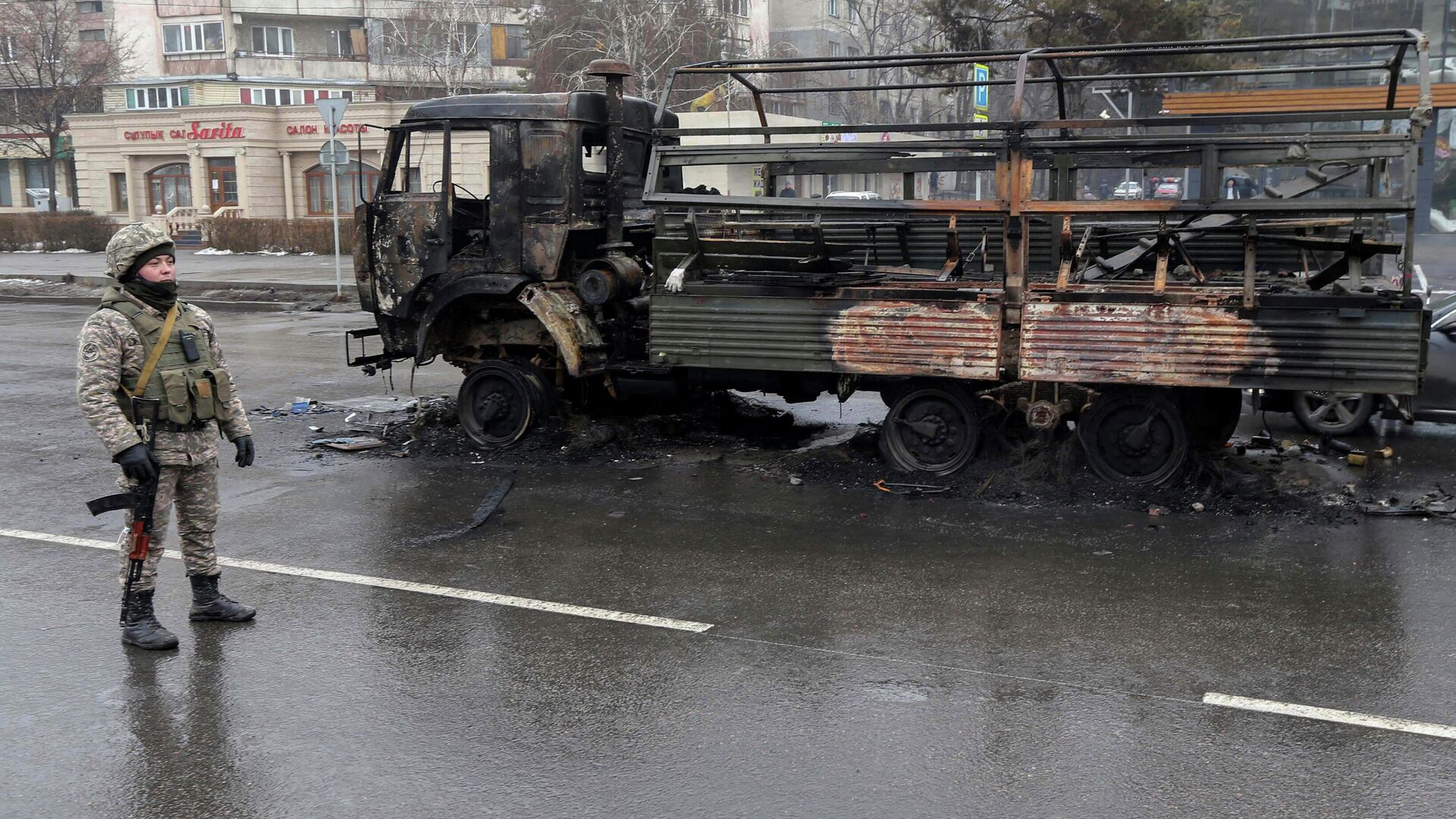Военный возле сгоревшего грузовика на одной из улиц в Алма-Ате - РИА Новости, 1920, 09.01.2022