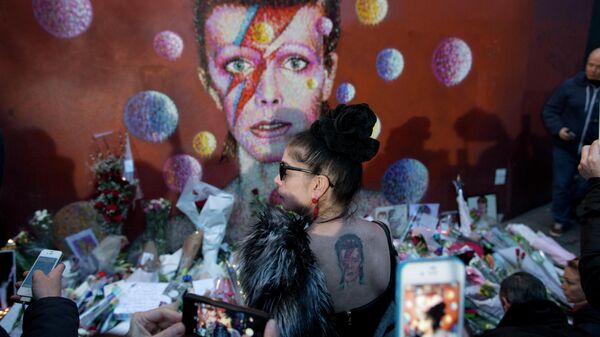 Женщина с татуировкой Ziggy Stardust у стены Дэвида Боуи в Лондоне, Великобритания. Январь 2016