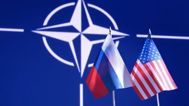 Флаги России и США на фоне логотипа НАТО