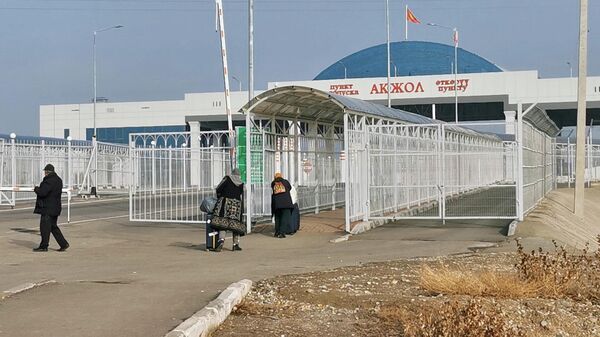 Люди проходят через границу Киргизии и Казахстана на автомобильном пункте пропуска Ак-Жол