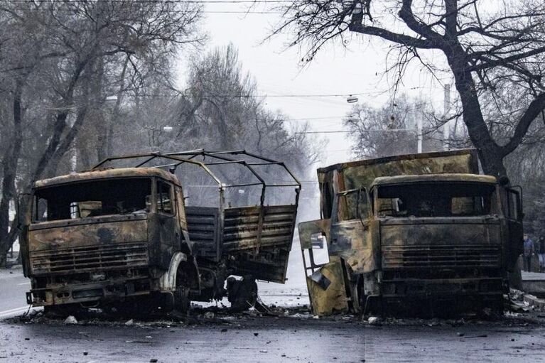 Сожженные грузовые автомобили на улице в Алма-Ате