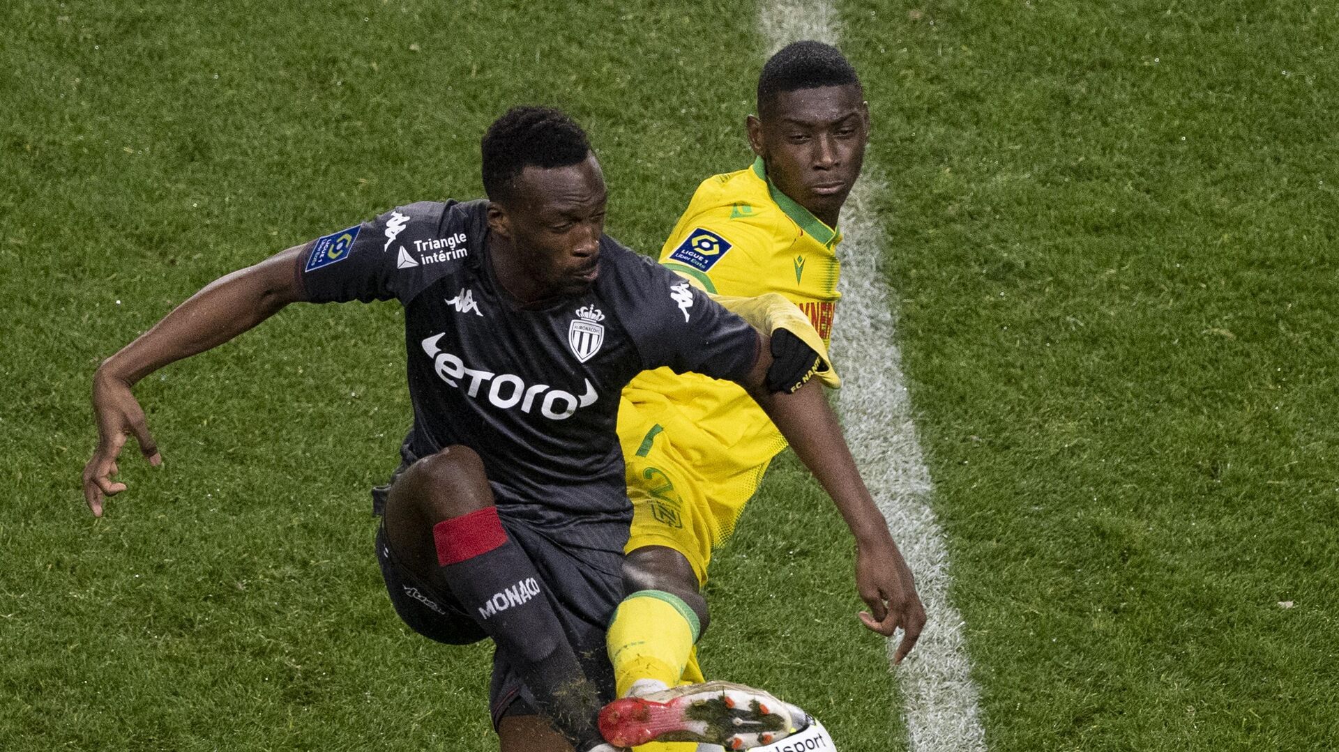 Monaco's French defender Chrislain Matsima (L) fights for the ball with Nantes' Congolese forward Randal Kolo Muani during the French L1 football match between FC Nantes and AS Monaco at the La Beaujoire Stadium in Nantes, western France, on January 9, 2022. (Photo by LOIC VENANCE / AFP) - РИА Новости, 1920, 09.01.2022