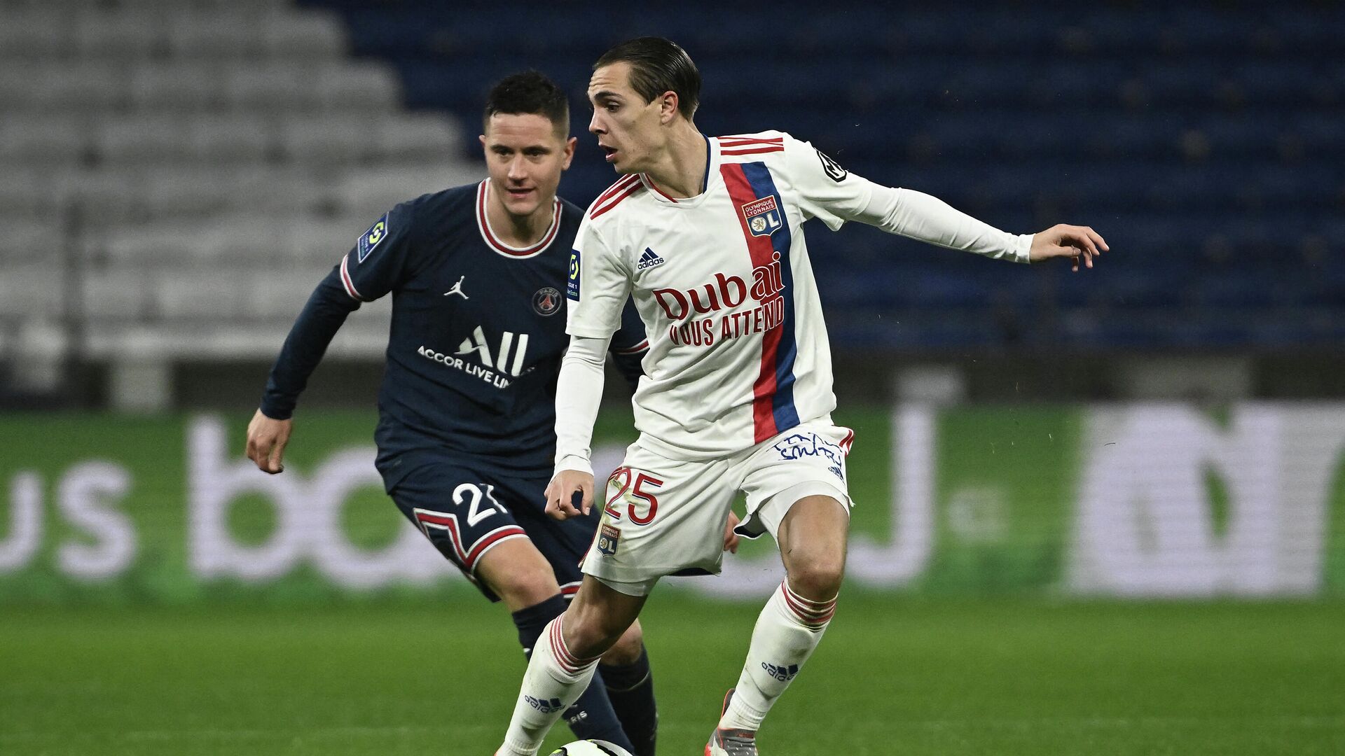 Lyon's French defender Damien Da Silva (L) challenges Paris Saint-Germain's Portuguese defender Nuno Mendes during the French L1 football match between Olympique Lyonnais and Paris Saint-Germain at the Groupama stadium in Decines-Charpieu near Lyon, central eastern France on January 9, 2022. (Photo by Jeff PACHOUD / AFP) - РИА Новости, 1920, 10.01.2022