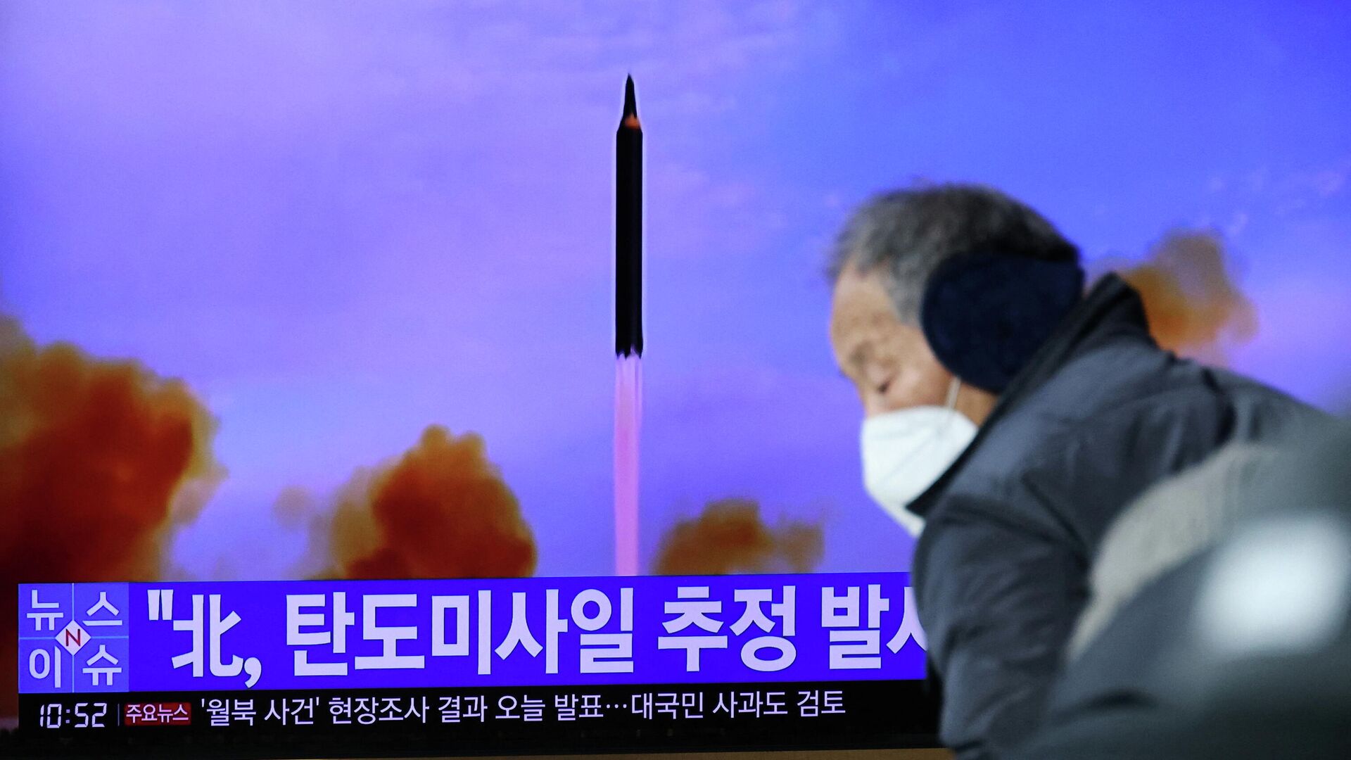 Мужчина проходит мимо экрана в Сеуле, транслирующего репортаж о запуске КНДР баллистической ракеты, 5 января 2022 - РИА Новости, 1920, 14.01.2022