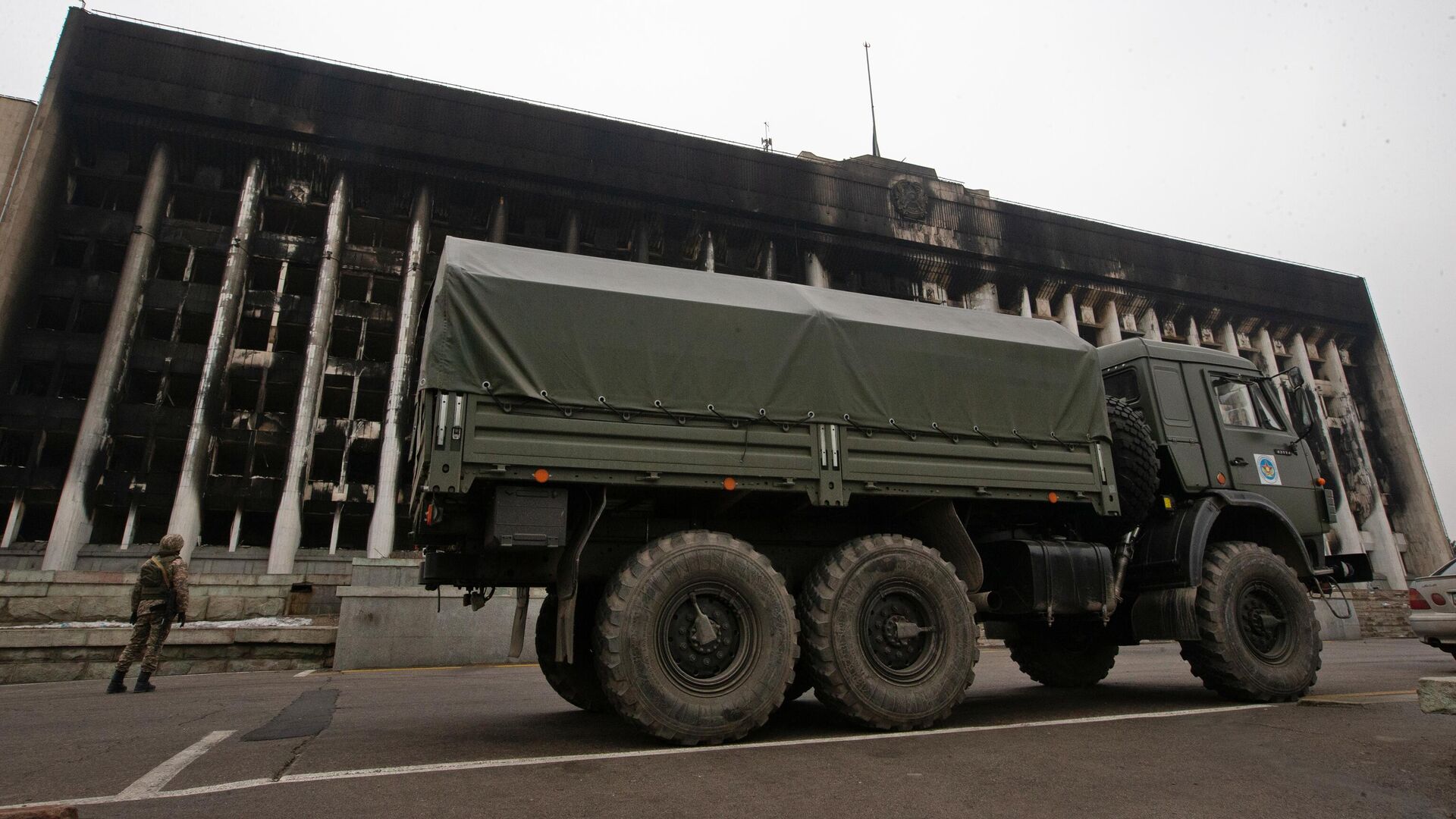 Военный автомобиль у сгоревшего здания акимата в Алма-Ате - РИА Новости, 1920, 12.01.2022