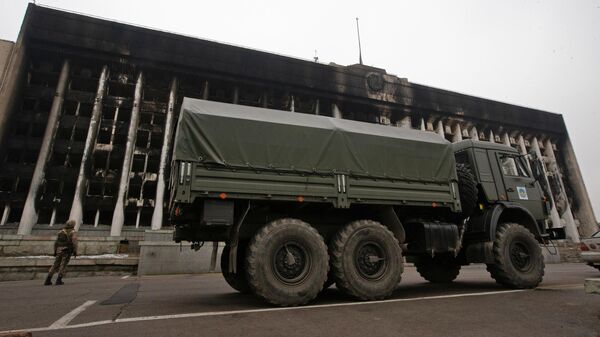 Военный автомобиль у сгоревшего здания акимата в Алма-Ате