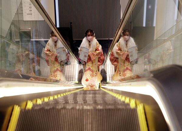 Девушка в кимоно едет на церемонию празднования Дня совершеннолетия в Токио, Япония. 10 января 2022 года