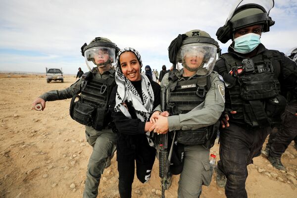 Бедуинская женщина во время задержания на акции протеста против посадки деревьев в пустыне Негев