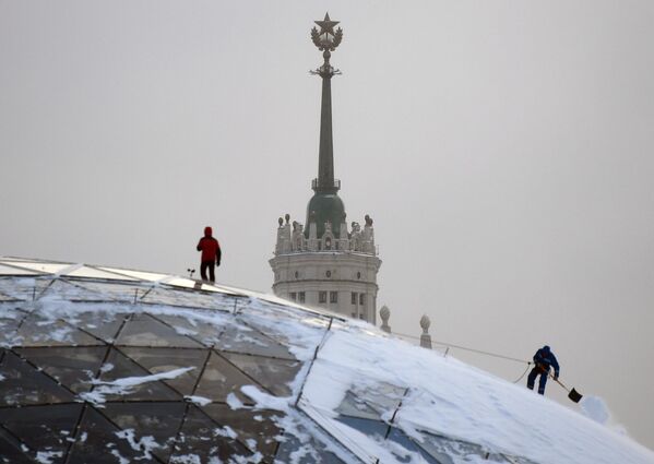 Сотрудники коммунальной службы чистят снег в парке Зарядье в Москве