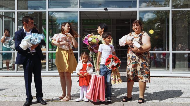 Многодетная семья во время торжественной новорожденных из родильного дома 