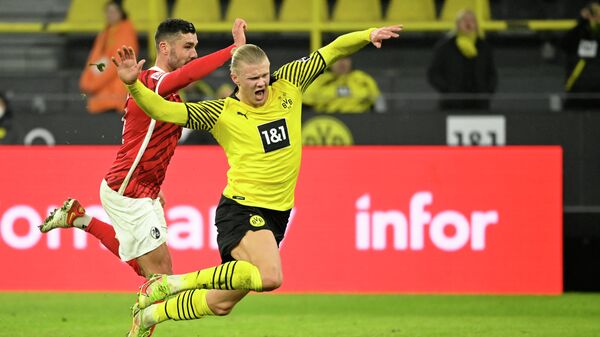 Freiburg's German defender Manuel Gulde (L) and Dortmund's Norwegian forward Erling Braut Haaland vie for the ball during the German first division Bundesliga football match between Borussia Dortmund v SC Freiburg in Dortmund, western Germany on January 14, 2022. (Photo by Ina Fassbender / AFP) / DFL REGULATIONS PROHIBIT ANY USE OF PHOTOGRAPHS AS IMAGE SEQUENCES AND/OR QUASI-VIDEO