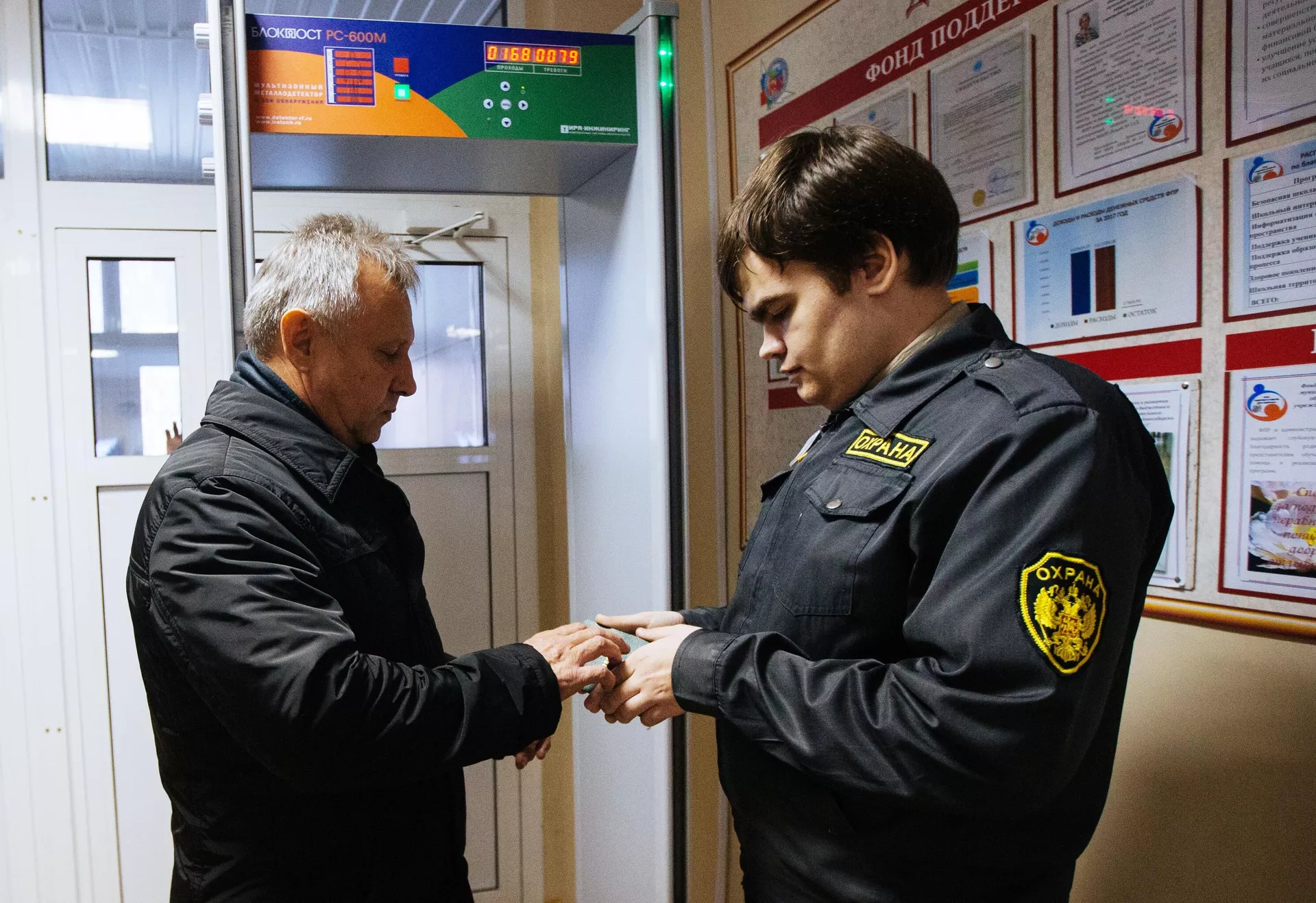 Охранник смотрит документы во время проверки мер безопасности в школах Новосибирска - РИА Новости, 1920, 15.01.2022