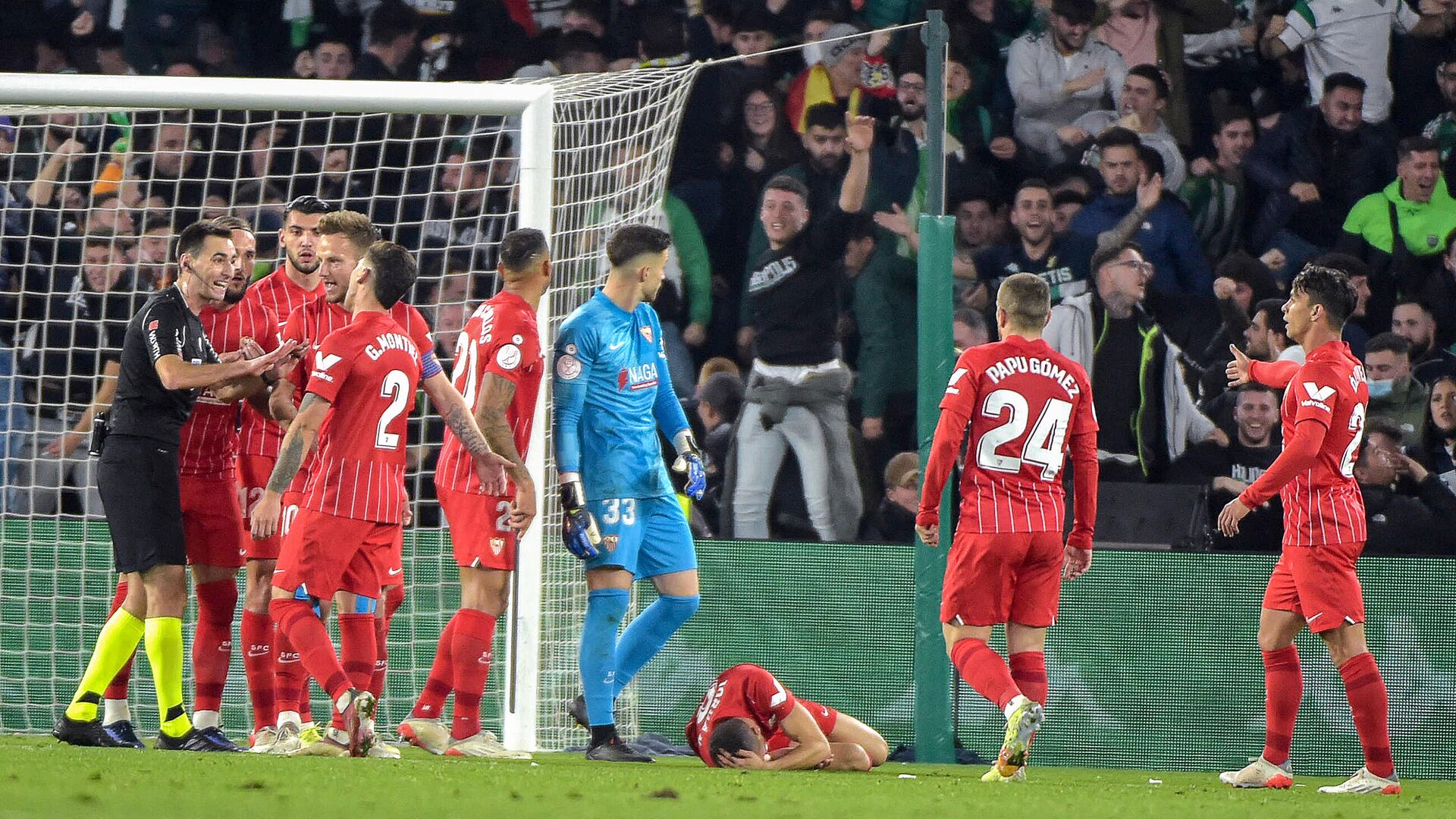 Sevilla's Spanish midfielder Joan Jordan Moreno (C) lies on the pitch after being hit by an object thrown from the tribunes during the Spanish Copa del Rey (King's Cup) round of 16 first leg football match between Real Betis and Sevilla FC at the Benito Villamarin stadium in Seville on January 15, 2022. - The Copa del Rey match between rivals Sevilla and Real Betis was stopped after Sevilla's Joan Jordan was struck on the head by an object thrown from the crowd. (Photo by CRISTINA QUICLER / AFP) - РИА Новости, 1920, 16.01.2022