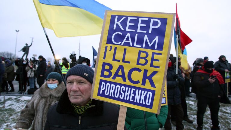 Сторонники экс-президента Украины Петра Порошенко с плакатами встречают бывшего главу государства возле здания терминала аэропорта Киев