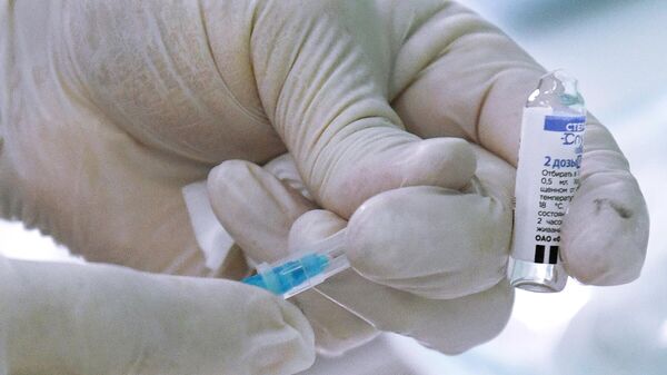 Медицинский сотрудник держит в руках ампулу с вакциной Спутник Лайт 