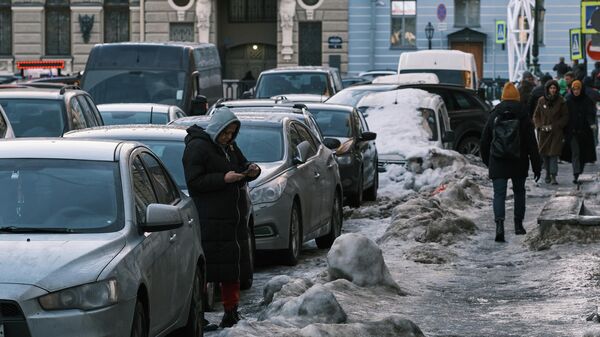 Прохожие идут по льду на тротуаре Итальянской улицы в Санкт-Петербурге