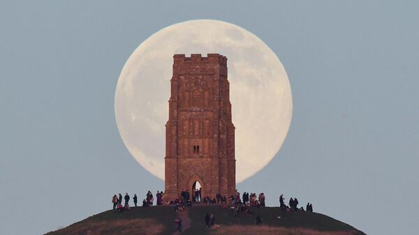 Люди наблюдают за Волчьей Луной в Гластонбери, Великобритания
