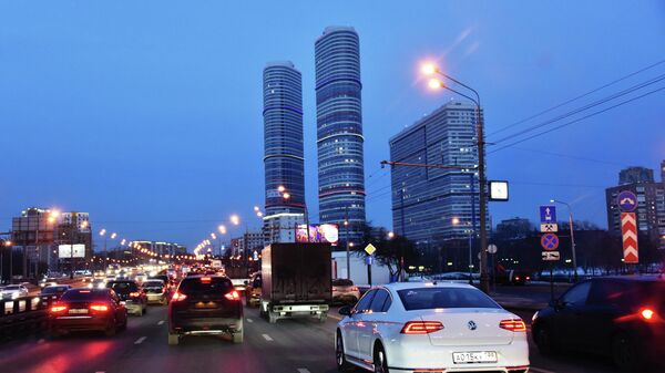Автомобили на проспекте Мира в Москве. На дальнем плане: здания жилого комплекса Триколор 