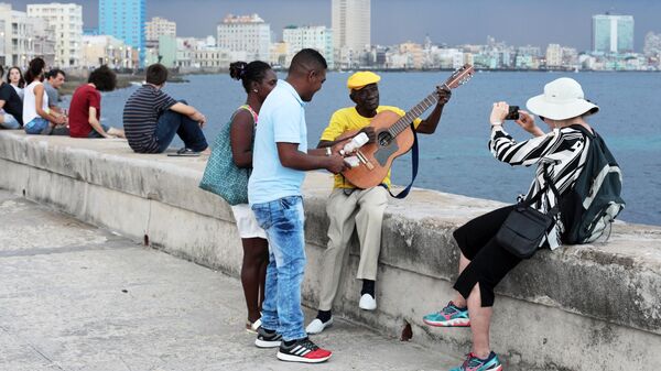 Кубинцы и туристы отдыхают на набережной Малекон в Гаване