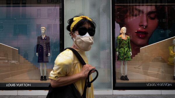 Женщина около витрины магазина Louis Vuitton в Нью-Йорке