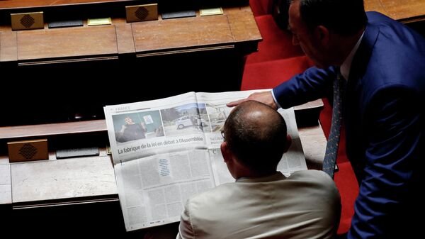 Члены парламента Франции читают газету Le Monde
