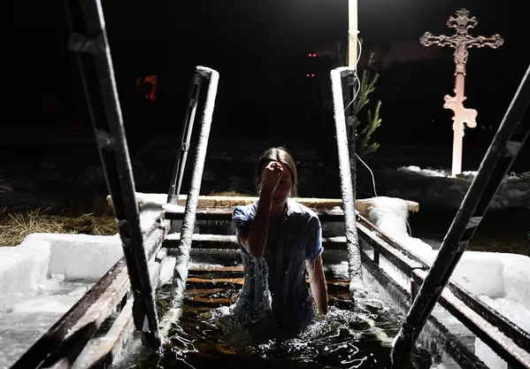 Девушка окунается в купель на Верх-Исетском пруду в Екатеринбурге во время празднования Крещения