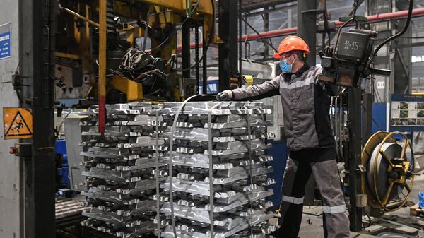 Рабочий на участке формирования и упаковки пакетов слитков из алюминиевого сплава в литейном цехе Хакасского алюминиевого завода