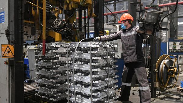 Рабочий на участке формирования и упаковки пакетов слитков из алюминиевого сплава в литейном цехе Хакасского алюминиевого завода