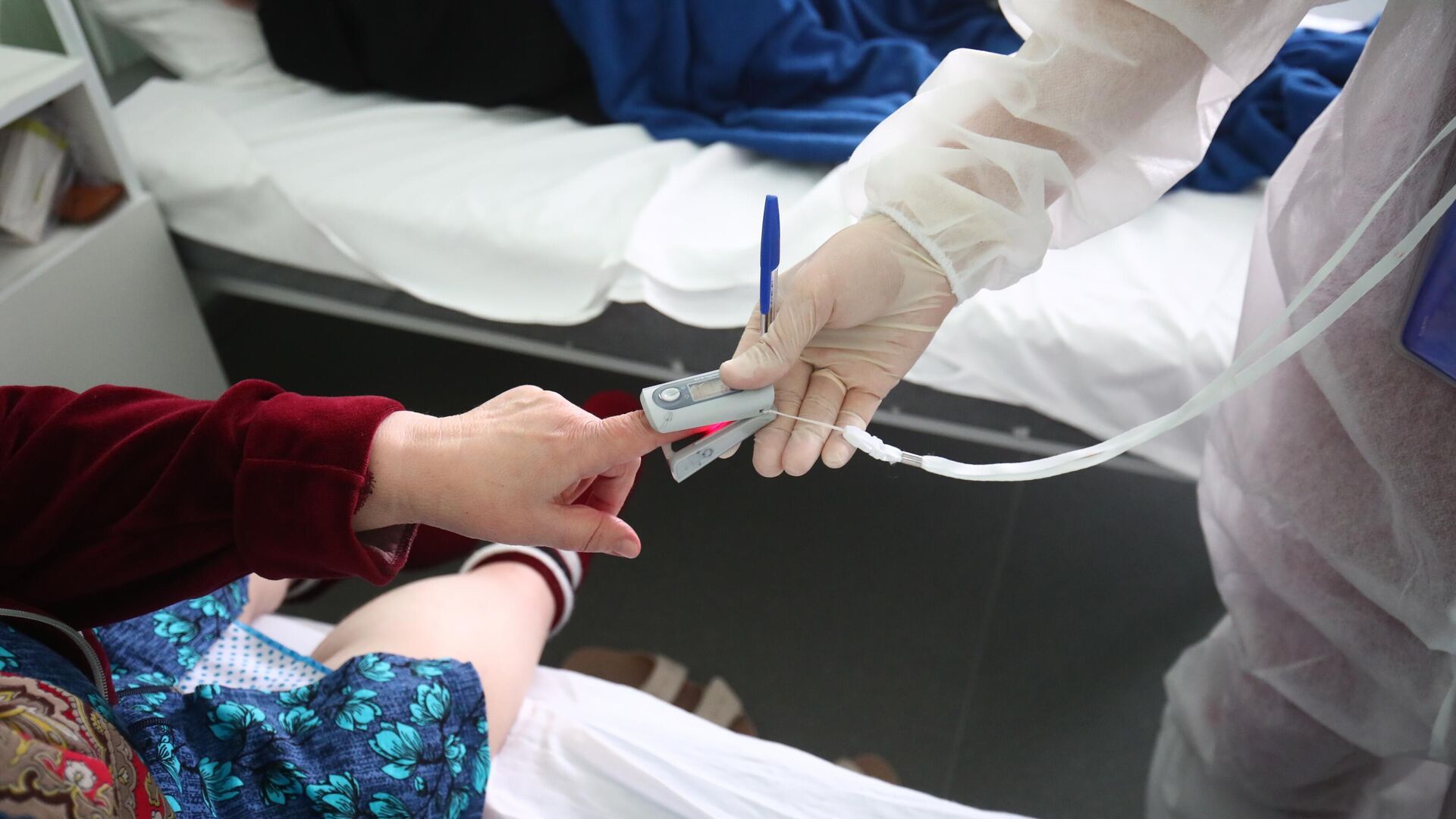 Медицинский сотрудник измеряет пульсоксиметром сатурацию у пациента Медицинский сотрудник измеряет пульсоксиметром сатурацию у пациента - РИА Новости, 1920, 23.01.2022