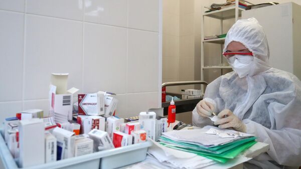 Медицинский сотрудник готовит лекарства к раздаче пациентам, больным COVID-19