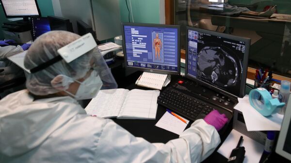 Медицинский сотрудник проводит компьютерную томографию пациенту с COVID-19
