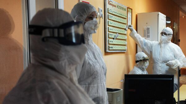 Медицинские работники на сестринском посту в красной зоне инфекционного отделения для лечения детей с COVID-19 