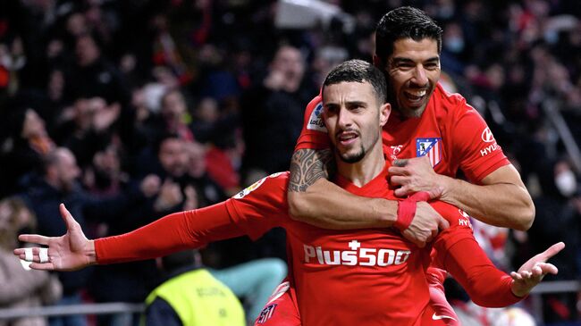 Atletico Madrid's Spanish defender Mario Hermoso (L) celebrates with Atletico Madrid's Uruguayan forward Luis Suarez after scoring his team's third goal during the Spanish league football match between Club Atletico de Madrid and Valencia CF at the Wanda Metropolitano stadium in Madrid on January 22, 2022. (Photo by PIERRE-PHILIPPE MARCOU / AFP)