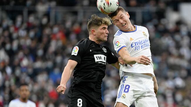 Elche's Spanish midfielder Raul Guti (L) vies with Real Madrid's German midfielder Toni Kroos for a header during the Spanish league football match between Real Madrid CF and Elche CF at the Santiago Bernabeu stadium in Madrid on January 23, 2022. (Photo by PIERRE-PHILIPPE MARCOU / AFP)