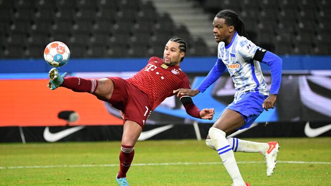 Bayern Munich's German midfielder Serge Gnabry (L) and Hertha Berlin's Belgian defender Dedryck Boyata vie for the ball during the German first division Bundesliga football match between Hertha Berlin and Bayern Munich in Berlin on January 23, 2022. (Photo by Tobias SCHWARZ / AFP) / DFL REGULATIONS PROHIBIT ANY USE OF PHOTOGRAPHS AS IMAGE SEQUENCES AND/OR QUASI-VIDEO