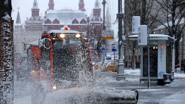 Снегоуборочная техника убирает снег на одной из улиц в Москве