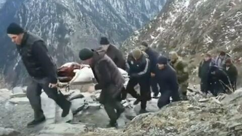 Стоп-кадр видео, на котором жители Хушета несут на носилках больную женщину