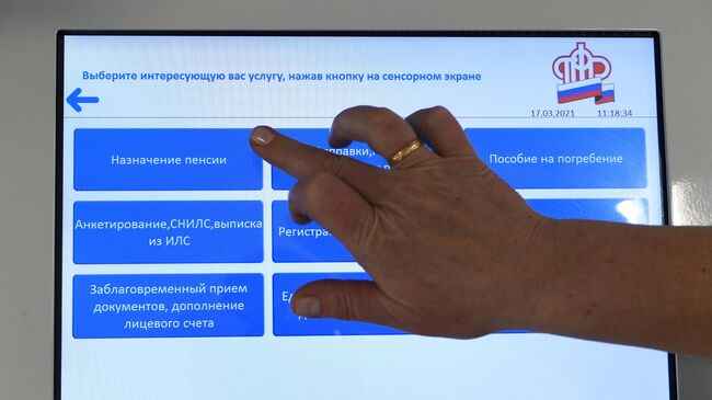 Человек выбирает услугу в терминале в ПФР