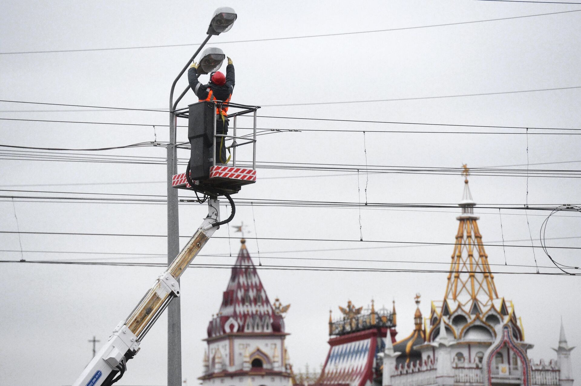 Сотрудник АО Объединенная энергетическая компания меняет лампы в уличных фонарях в Москве - РИА Новости, 1920, 25.01.2022